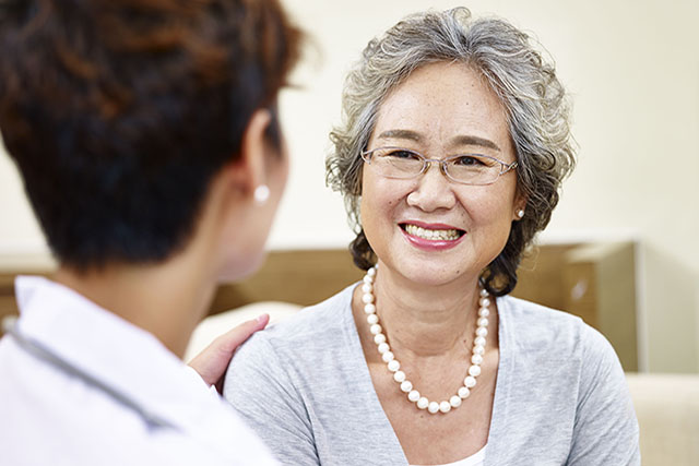 senior asian woman talking to family doctor
